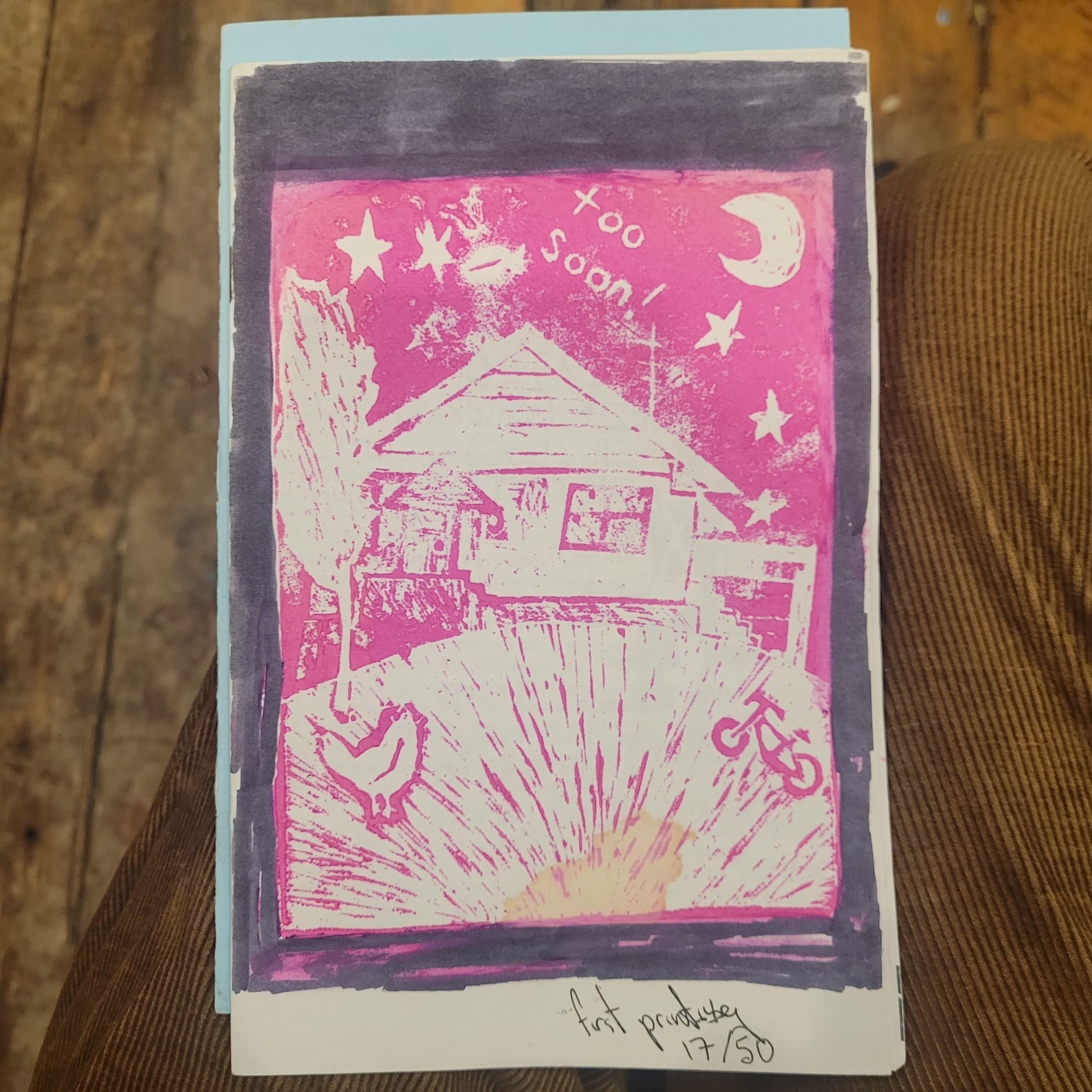 pink block print of house with chicken, tree and bike